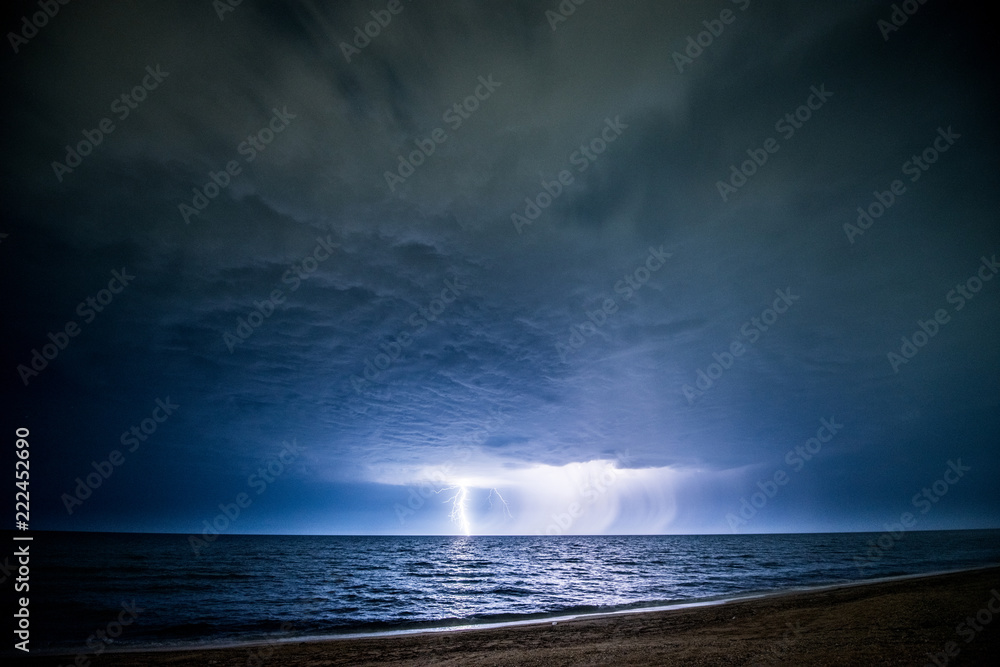 Night thunderstorm with lightning above the sea