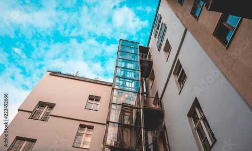 glass elevator at apartment house with fluffy background sky photo