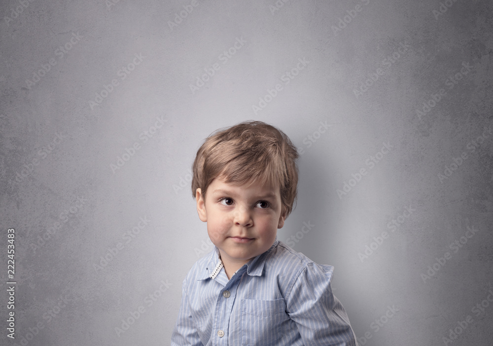 Fototapeta premium Adorable little boy portrait with empty grey wall background