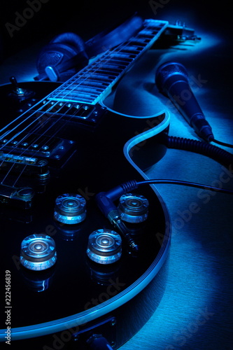 Electric guitar,headphones and microphone.Music concept.Selective focus.In the dark
