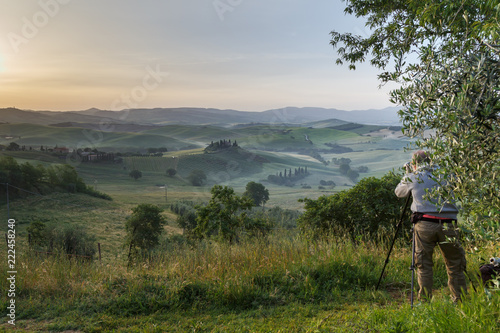 Photographing at sunrise beautiful Tuscany landscape with traditional farm house, hills and meadow. Val d'orcia, Italy. Holidays in Italy.