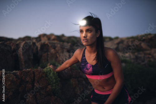 Sportive woman with headlamp in the evening