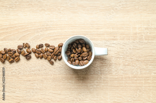 Coffee beans with cup on wooden table