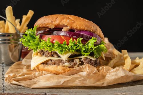 Burger with potatoes. Served on a wooden background photo