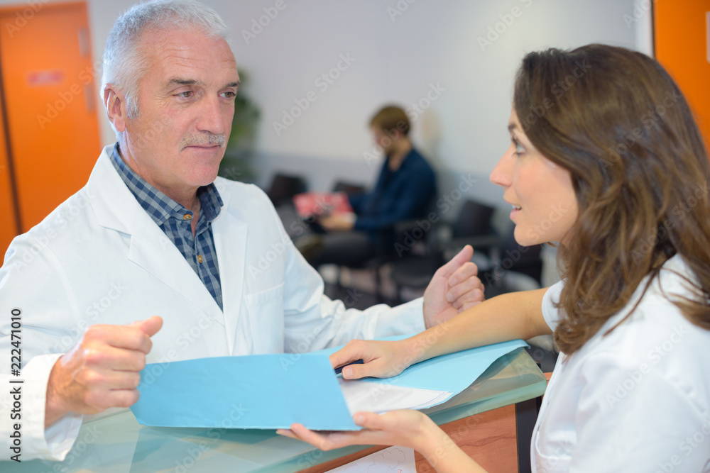 Obraz premium Doctor and receptionist looking at files