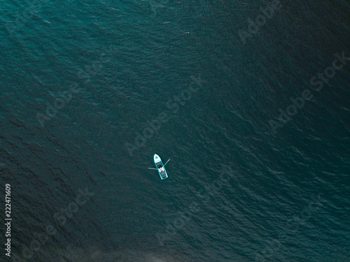 Young wedding couple sailing on a boat with oars at sea. View from the top. Aerial photography