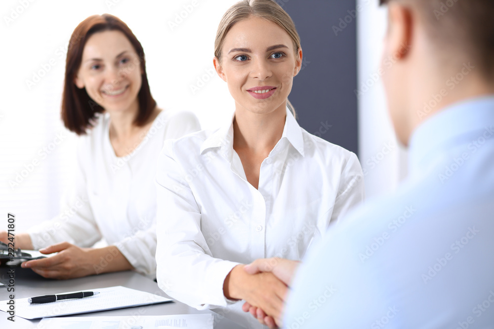 Business handshake by blonde woman and her partner at meeting. Concept of success and agreement Business handshake by blonde woman and her partner at meeting. Concept of success and agreement