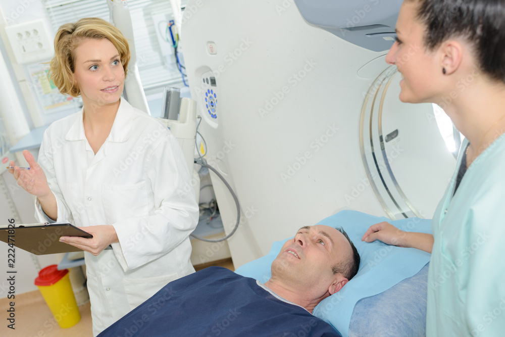 Nurses stood beside patient on scanner bed Nurses stood beside patient on scanner bed