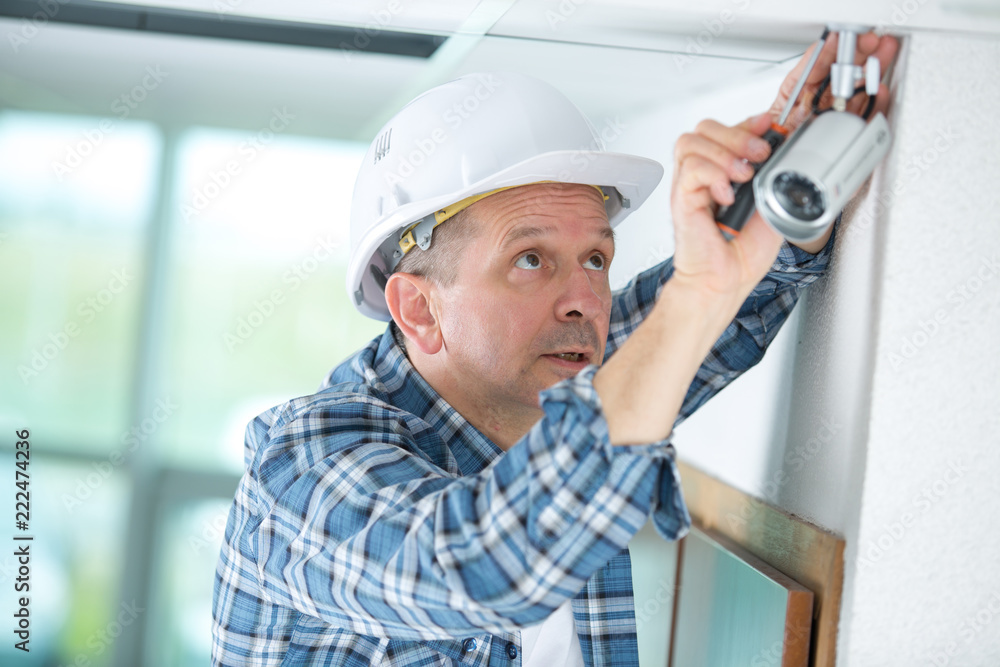 technician worker installing video surveillance camera on wall technician worker installing video surveillance camera on wall
