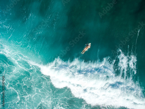 vertical shot leaky peak drone a-frame sumbawa surf ocean crystal white paddle girl