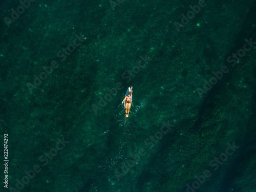 vertical shot leaky peak drone a-frame sumbawa surf ocean crystal green paddle girl