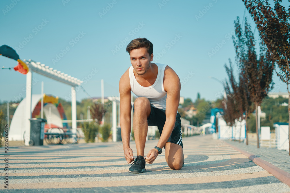 Determined young male runner getting ready to start running