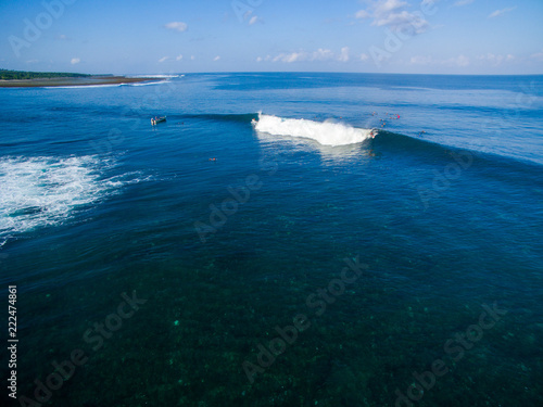 leaky peak perfection a-frame lines blue horizon sumbawa surfers left right takeoff photo