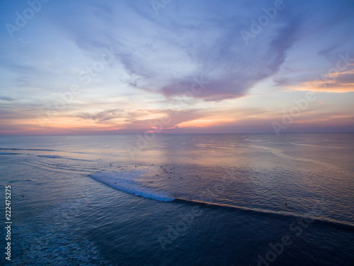 bingin beach sunset over bali surf lines clouds colors surfer indonesia photo