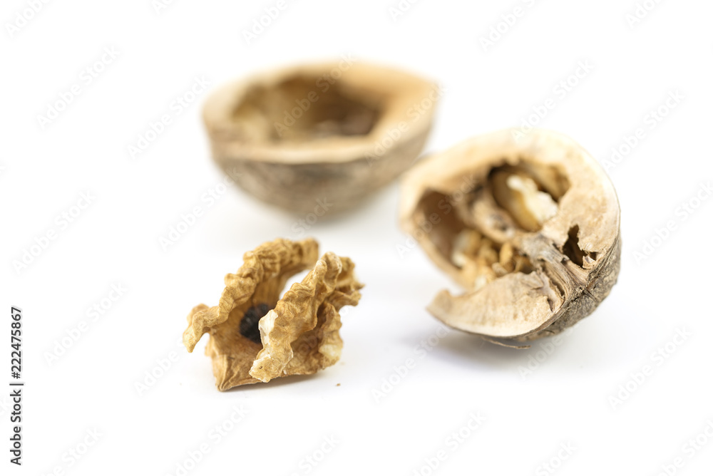 cracked walnut, nutshell and kernel, close up isolated with shadows on a white background, copy space cracked walnut, nutshell and kernel, close up isolated with shadows on a white background, copy space