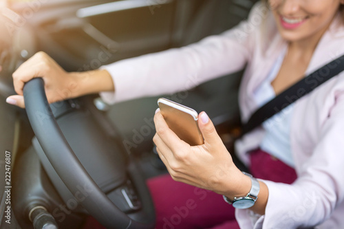 Woman with smart phone in a car 