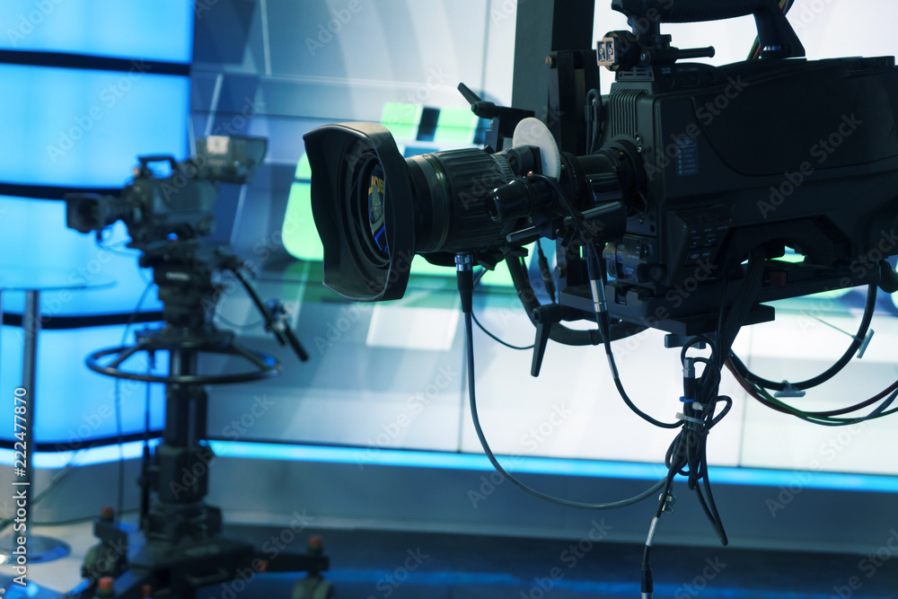 Broadcast television studio camera and crane camera in news studio room with LED lights Broadcast television studio camera and crane camera in news studio room with LED lights