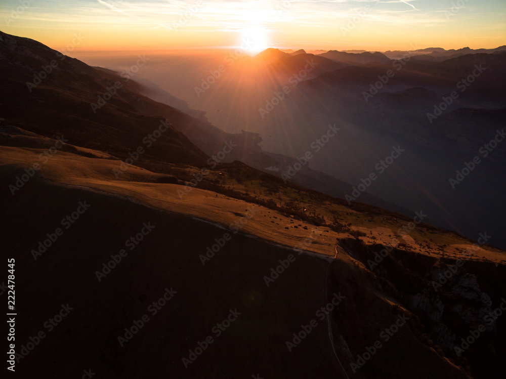 monte baldo garda lake italy drone shot aerial view sunset mountains dust path colors