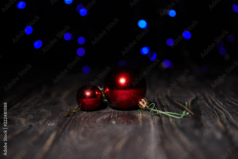 shiny red christmas balls on wooden table with blue sparkling background shiny red christmas balls on wooden table with blue sparkling background