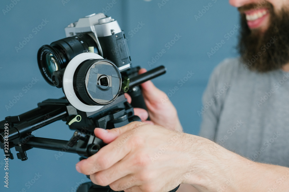 modern technology for video shooting. man using camera holder for easy and comfortable footage creation. equipment and tools for blogging concept.
