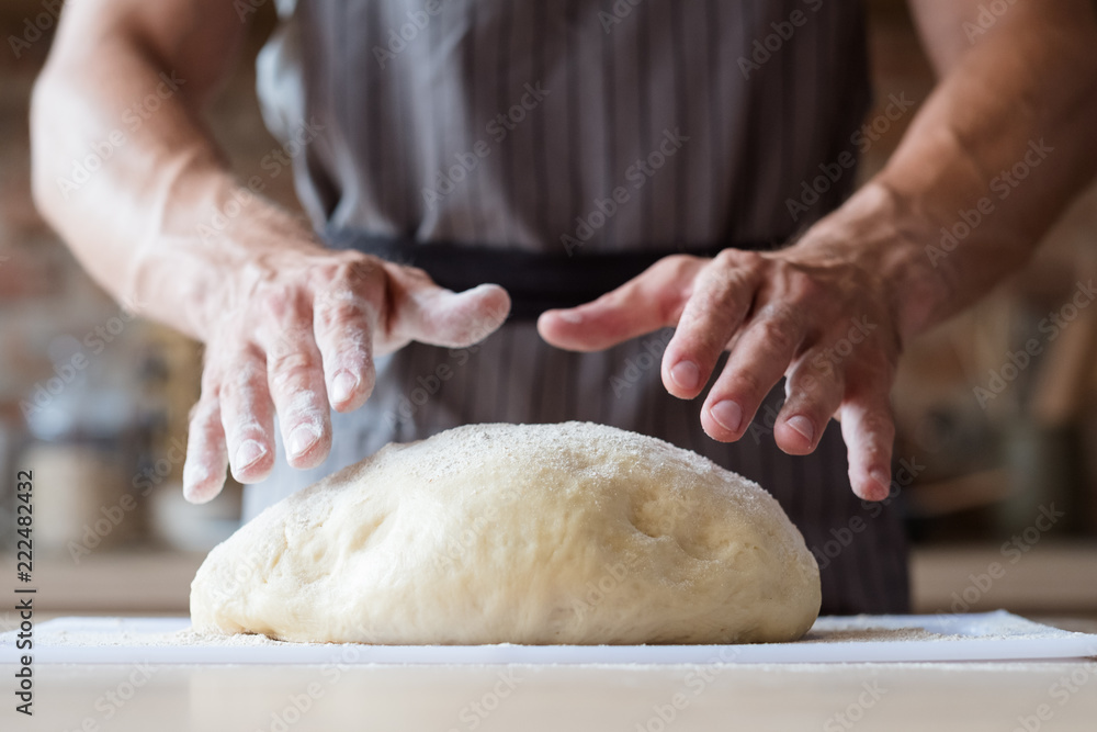 Fototapeta premium food cooking concept. chef preparing homemade bread or puff pastry. man hands ready to knead dough.