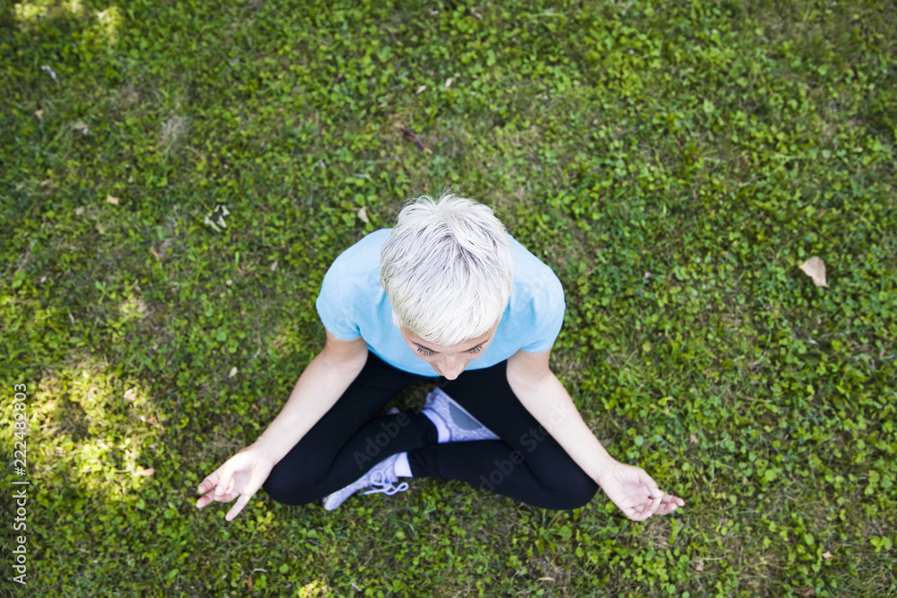 Top view at senior woman does lotus pose for relaxation Top view at senior woman does lotus pose for relaxation