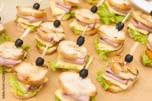 appetizer of baked baguette with ham, cheese, lettuce and olives, snacks