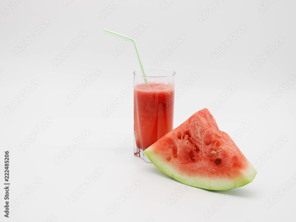 Watermelon slice and a glass of watermelon juice with a straw. Watermelon slice and a glass of watermelon juice with a straw.