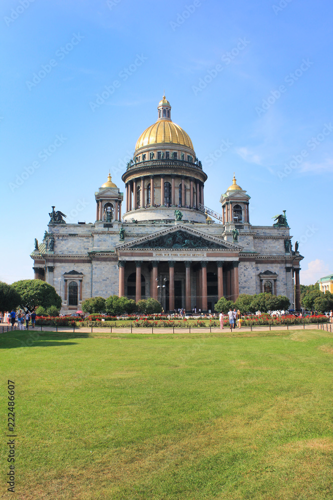 Saint Isaac's Cathedral in St. Petersburg, Russia. Church Facade Building Architecture View with Empty Green Grass Park Glade. Saint Isaac Cathedral City Attraction on Sunny Summer Day Background