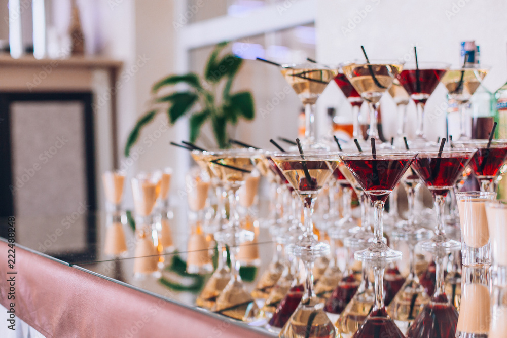 Delicious wedding reception candy bar dessert table. A lot of alcohol and glasses. Coktails and sweets. Wedding party table.
