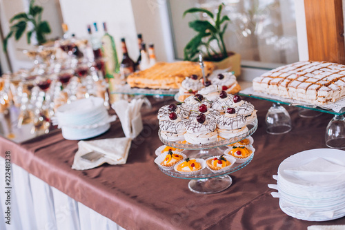 Delicious wedding reception candy bar dessert table. A lot of alcohol and glasses. Coktails and sweets. Wedding party table.