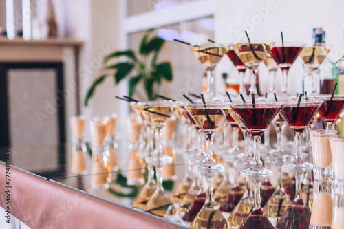 Obraz na płótnie Delicious wedding reception candy bar dessert table. A lot of alcohol and glasses. Coktails and sweets. Wedding party table. w salonie