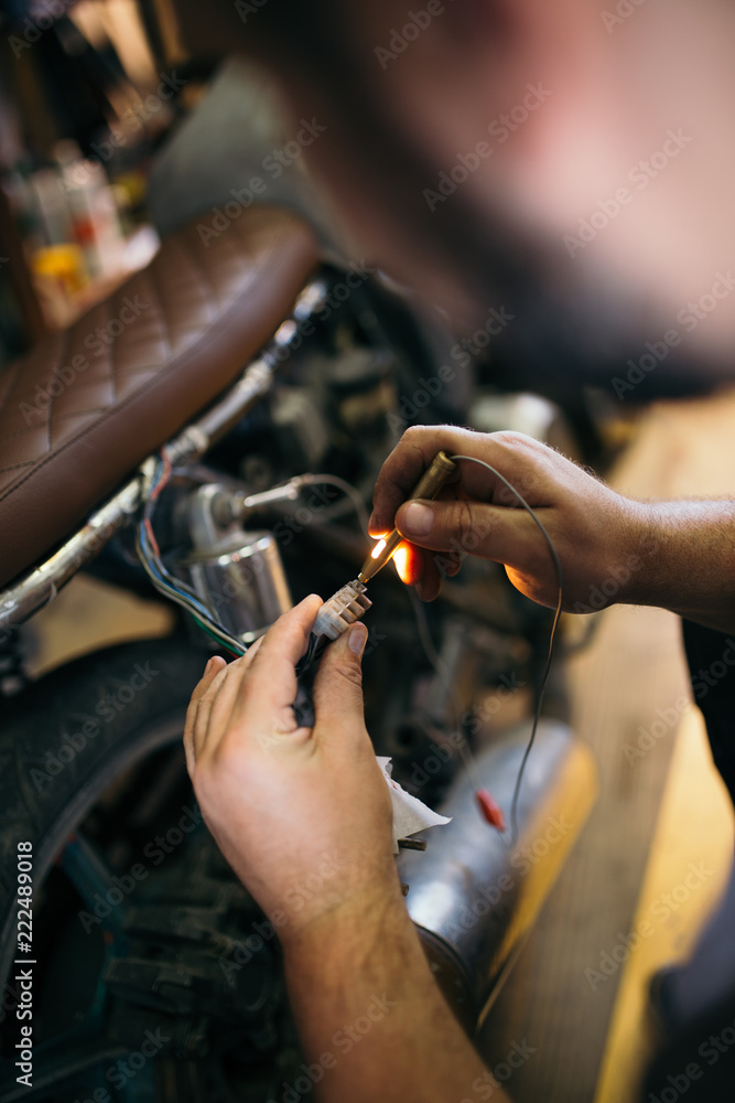 Fototapeta premium Close up shot of experienced man working in custom made motorcycle workshop.