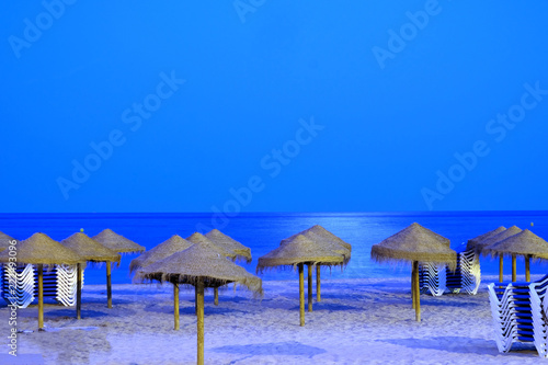 beach umbrellas and sunbeds at night on the beach