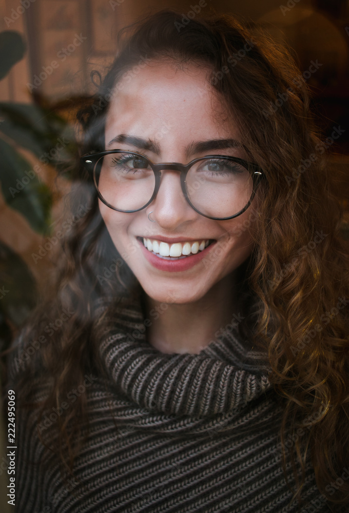 Warm, wintery portrait of young adult, female, gazing out the window with drops of water and bokeh Warm, wintery portrait of young adult, female, gazing out the window with drops of water and bokeh
