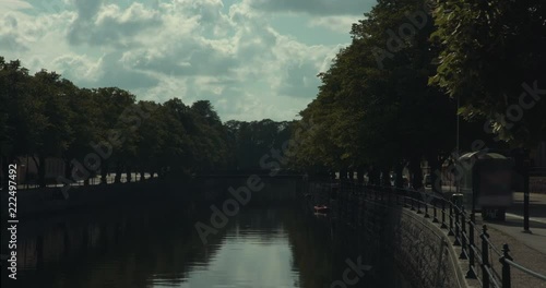 Timelapse of a canal in Gävle, with cars driving and clouds moving photo