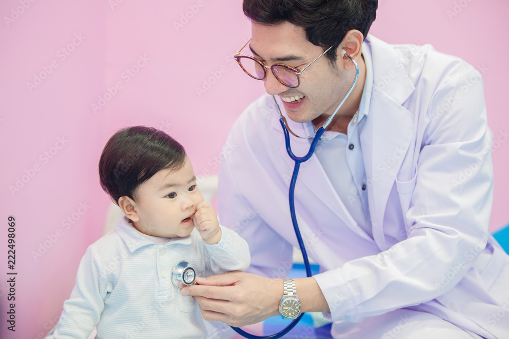 happy african male doctor examining baby boy with female nurse on background happy african male doctor examining baby boy with female nurse on background