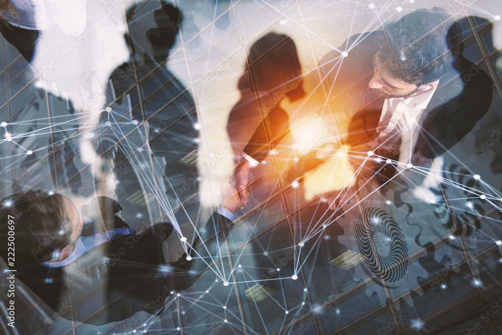 Handshaking business person in office. concept of teamwork and partnership. double exposure with gears system and network effects Handshaking business person in office. concept of teamwork and partnership. double exposure with gears system and network effects
