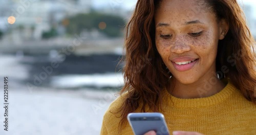 Woman using mobile phone on beach 4k photo