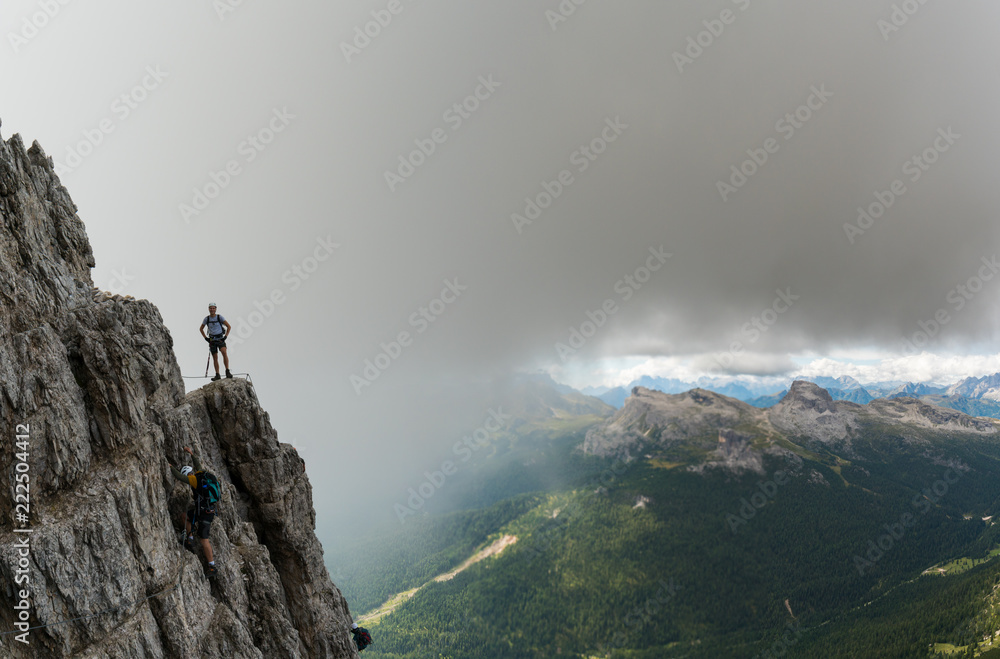 two young male mountain climbers on very exposed Via Ferrata in Alta Badia in the Italian Dolomites
