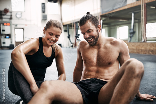 Young couple smiling while taking a break from working out