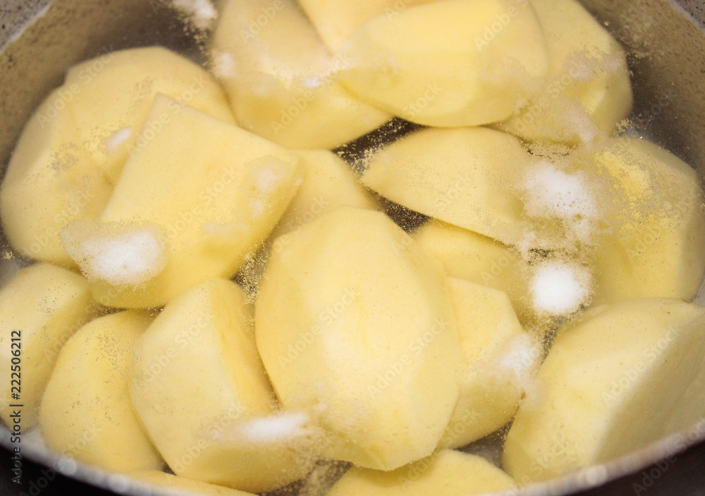 Peeled potatoes in a pot of water