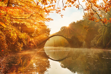 Papier peint photo Le Rakotzbrücke Rakotzbrücke aube orangée et brouillard mystique  © kenopictures