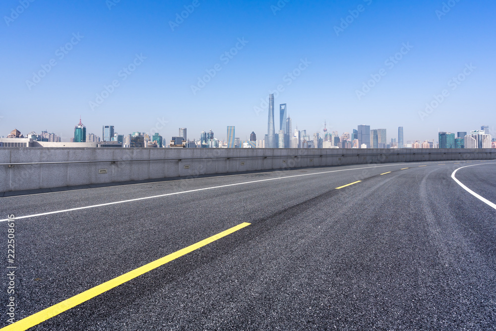 empty asphalt road with city skyline