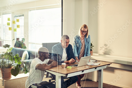 Diverse businesspeople working together on a laptop in an office