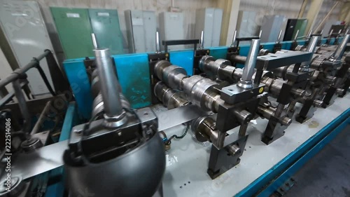 Profiles are created on the metal rolling machine at the plant. creation of profiles, machine for creation of steel profiles from steel sheet. close-up