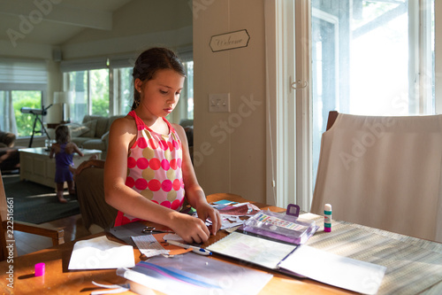 A girl making paper doll at home photo