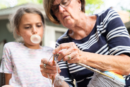 Grandmother teaching knitting to granddaughter