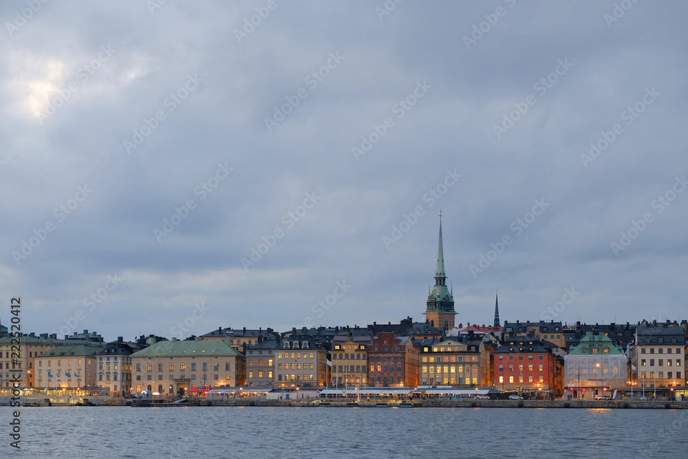 Cityscape of Gamla Stan in Stockholm, Sweden, at sunset. Old city of Stockholm at sunset during blue hour. Street lights ar on. Traces of car lamps at the foreground.