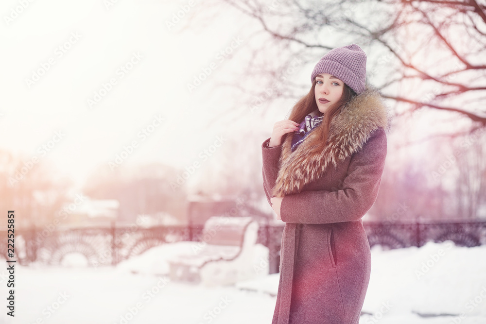 A young girl in a winter park on a walk. Christmas holidays in t A young girl in a winter park on a walk. Christmas holidays in t